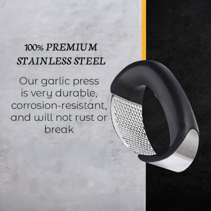 A stainless steel garlic press tool shown on a split gray and black background with text reading '100% PREMIUM STAINLESS STEEL' and descriptive copy about durability.
