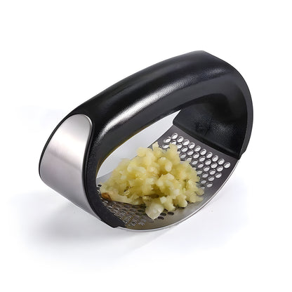 Garlic press with minced garlic on a white background
